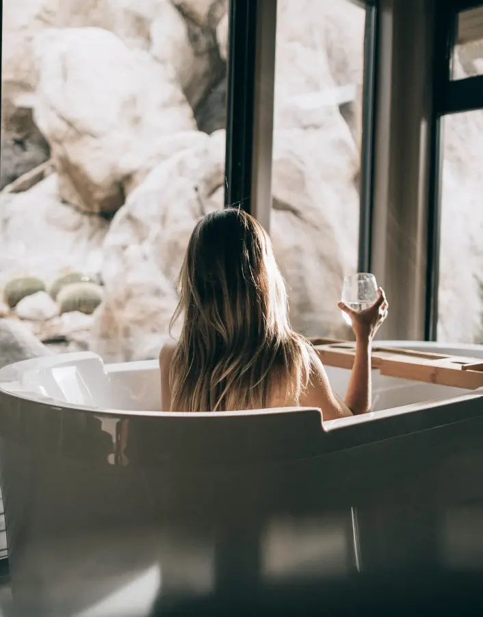 Blonde FEMMENORDIC model with silky hair sat in a bathtub.